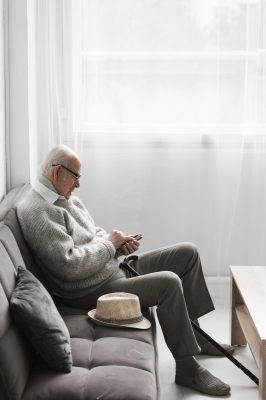 side-view-senior-man-nursing-home-using-smartphone